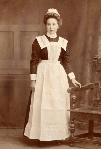 A girl who has completed her training and is ready, with her uniform, to go out to work in domestic service, 1910