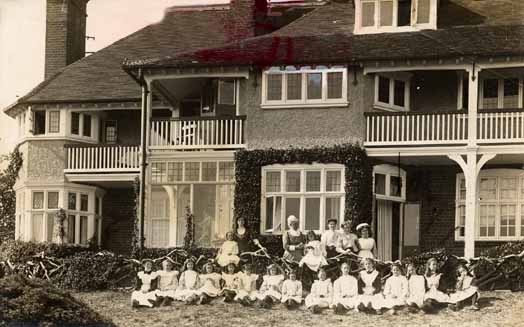 Matron, Staff and Girls pose outside the front of 'Coronation Cottage'