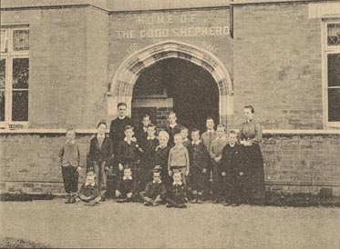 The boys, Chaplain and Matron stand outside the front of the Home