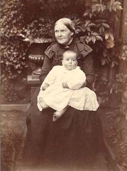 With her long dark dress and tied back hair, this elderly matron's appearance is typical of a late Victorian matriarch. 