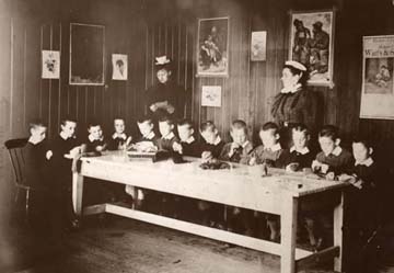 Under the watchful eye of their matrons, the young Standon lads learn how to darn their socks.