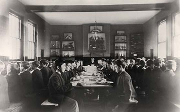 The Standon Boys enjoy a meal in the grand setting of their dining hall. The Master of the Home sits at the head of the middle table.